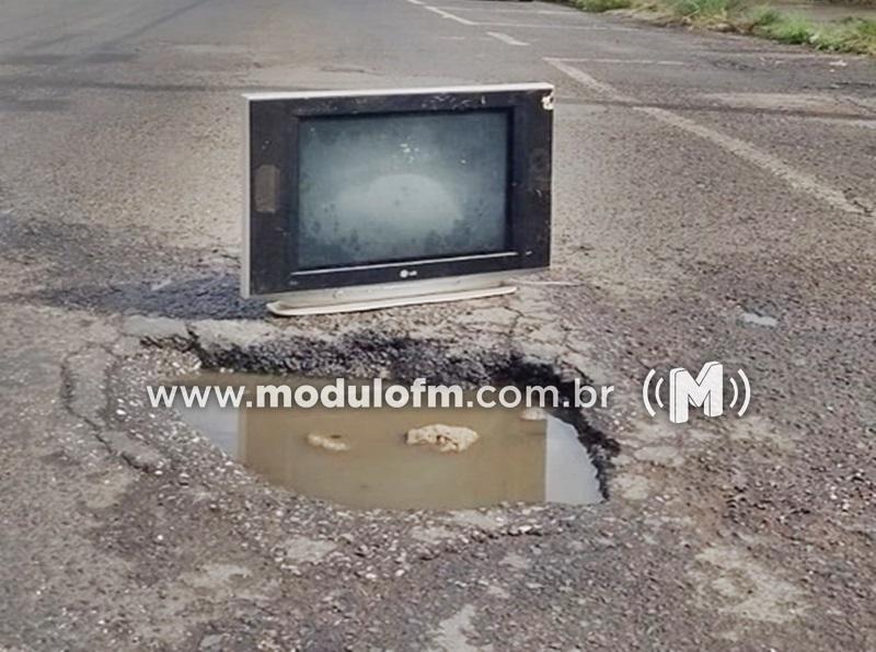 Moradores usam TV antiga para sinalizar buraco na rua...